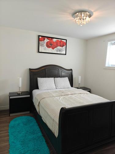 a bedroom with a bed with a black frame and a blue rug at Appartement sur deux niveaux in Quebec City