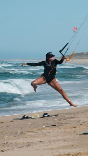 a woman jumping in the air on the beach at Amina Wind Resort by Tasman in Salinas