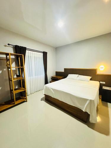 a bedroom with a bed and a book shelf at Mama Homestay in Kuta Lombok
