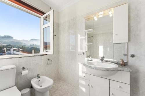 a white bathroom with a sink and a toilet at Vale do Vez in Arcos de Valdevez