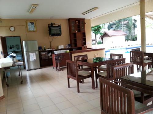 a living room with a table and chairs and a refrigerator at C.A.P Mansion in Phuket Town