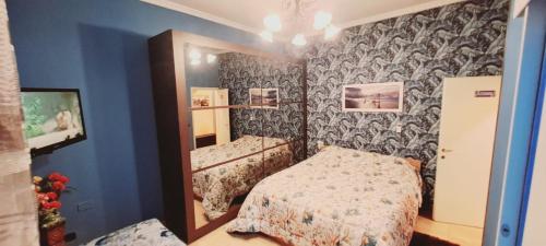 a small bedroom with a bed and a mirror at B&B JOY in Nettuno