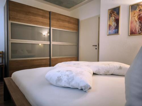 two beds in a hotel room with white sheets at Klaus Luttach in Lutago