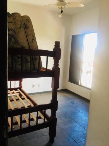 a room with a bed and a window and a chair at Edifício Nautilus in Guarujá