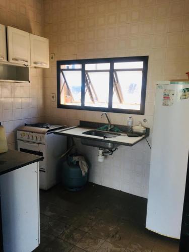 a small kitchen with a sink and a window at Edifício Nautilus in Guarujá