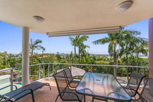 a patio with chairs and a table on a balcony at Bali Hai Apartments Noosa in Noosa Heads