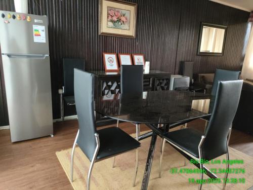 a dining room with a table and chairs and a refrigerator at Casa Amoblada para Empresas in Los Ángeles
