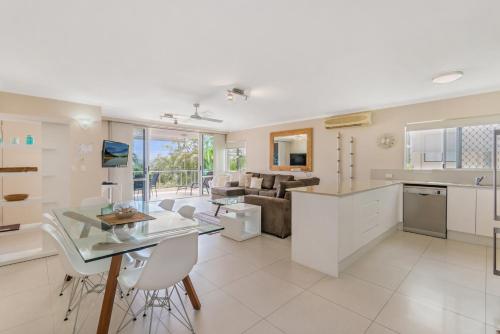 a kitchen and living room with a table and chairs at Bali Hai Apartments Noosa in Noosa Heads