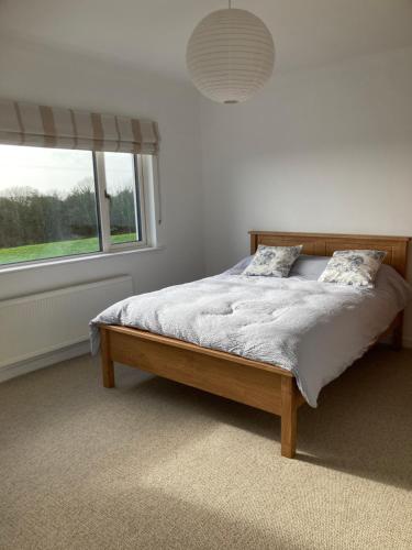 a bed in a bedroom with a large window at Ocean View in Rosscarbery