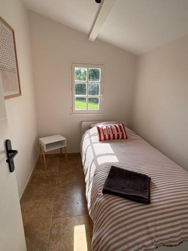 a small bedroom with a bed and a window at le mas au pied du Ventoux in Carpentras