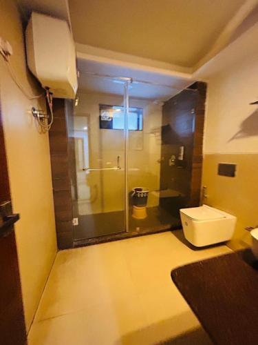 a bathroom with a toilet and a glass shower door at mayur Mora in Rāmgarh