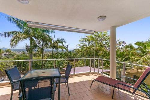 a balcony with a table and chairs and a view of the ocean at Bali Hai Apartments Noosa in Noosa Heads