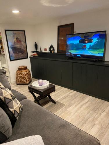 a living room with a couch and a flat screen tv at Private Oakland Hills Guest Apartment in Oakland