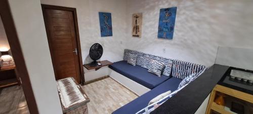 a blue couch in a room with a door at Porto do Sol - Chalé 07 in Pipa