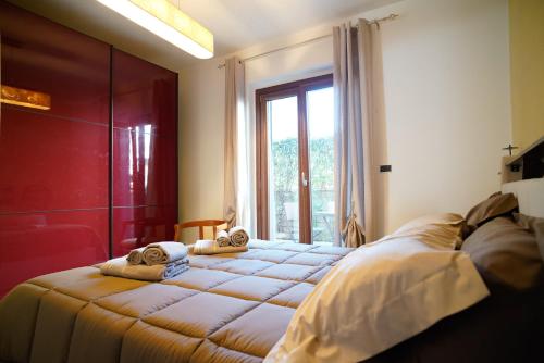 two beds in a room with a window at Villa Kappa - disponibili anche camere climatizzate - in LʼAquila