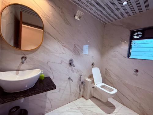 a bathroom with a sink and a toilet and a mirror at Hotel Classic Badlapur - Premium Couple Friendly Hotels in Badlapur in Badlapur