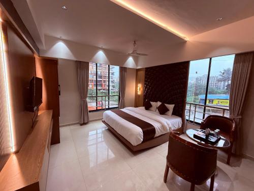 a hotel room with a bed and a desk and windows at Hotel Classic Badlapur - Premium Couple Friendly Hotels in Badlapur in Badlapur