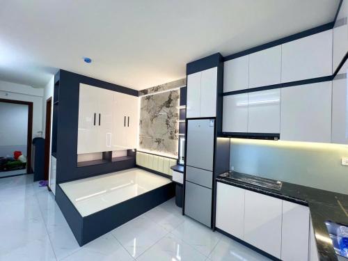 a large kitchen with white cabinets and a sink at Trang Due homestay in An Dương
