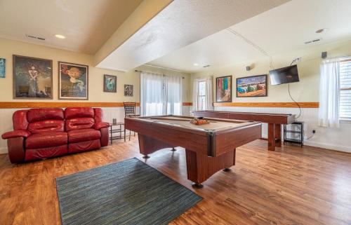 a living room with a pool table and a couch at Funtiki - S Nags Head MP 17.5, Semi-Oceanfront, 150 Yds to Beach, Pool, Hot Tub, Pool Table, Pets OK in Whalebone