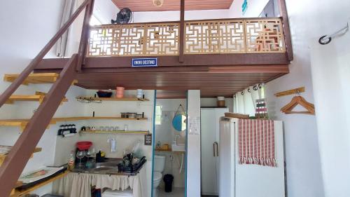 a room with a staircase and a refrigerator at Chalé Almar - Praia do Sagi in Baía Formosa