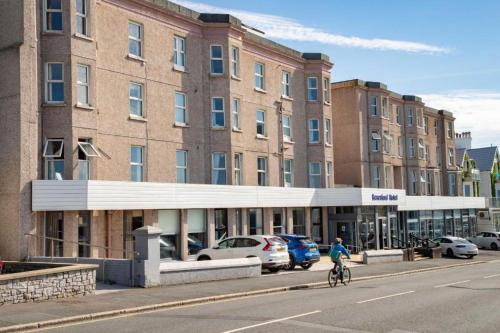 a person riding a bike in front of a building at The Beresford Hotel in Newquay