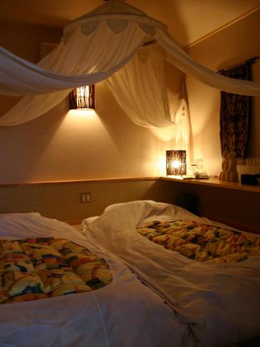 1 cama en un dormitorio con cortinas y 1 cama sidx sidx en Rurika, en Izu