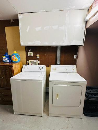 two washing machines sitting next to each other in a room at Cozy Private Apartment with 2 Queen size Beds in Moncton