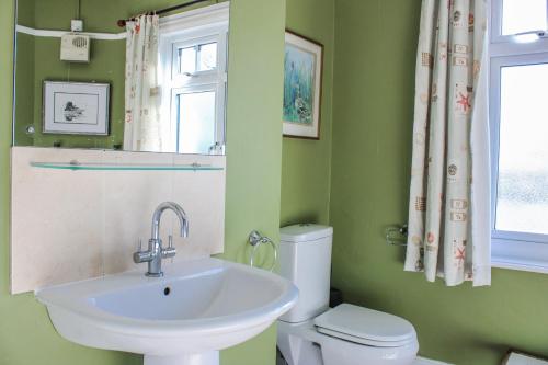 a bathroom with a sink and a toilet and a window at Waders in Salcombe