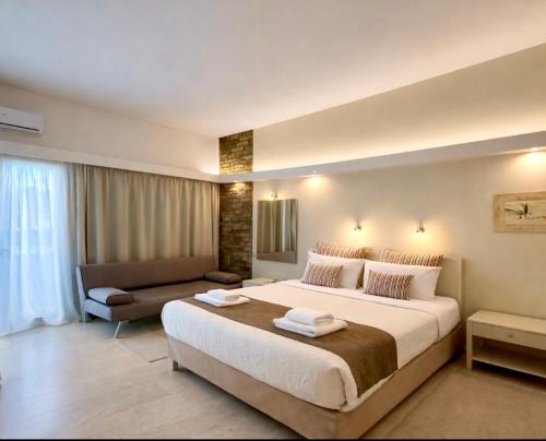 ein Hotelzimmer mit einem großen Bett und einer Couch in der Unterkunft Nidimos Hotel in Delphi