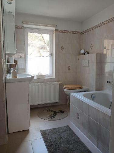 a bathroom with a tub and a toilet and a sink at Ferienhaus-Juliana in Stolberg
