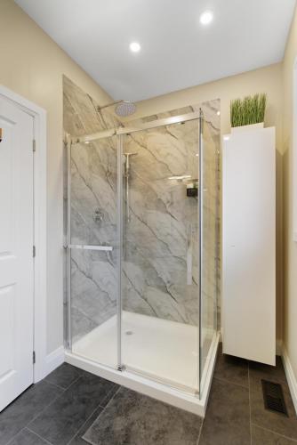 a shower with a glass door in a bathroom at Redwood Suite - NOTL Prime Location GETAWAY in Niagara-on-the-Lake