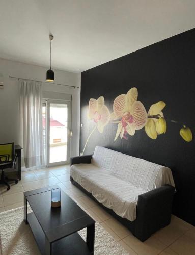 a bedroom with a bed with flowers on the wall at Zoes apartments in Orestiada
