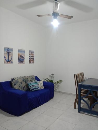 a blue couch in a living room with a table at Refúgio da Aldeia - trabalho ou lazer! in São Pedro da Aldeia