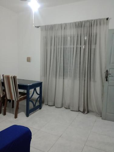 a living room with a table and a window at Refúgio da Aldeia - trabalho ou lazer! in São Pedro da Aldeia