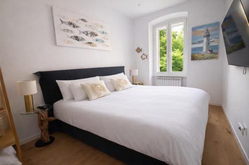 a bedroom with a large white bed with a window at Boutique Apartment Trieste in Trieste