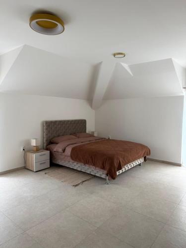 a bedroom with a bed in a white room at Apartmani Preradović in Pančevo