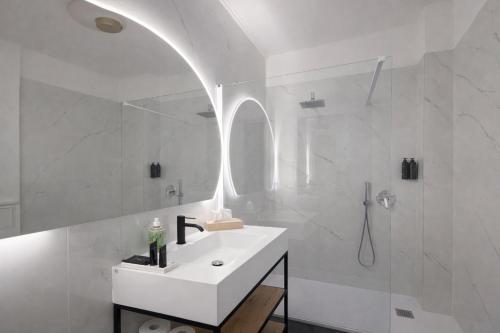 a white bathroom with a sink and a shower at Boutique Apartment Trieste in Trieste