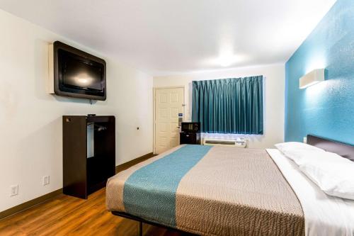 a hotel room with a bed and a flat screen tv at Motel 6-Bryan, TX - College Station in Bryan