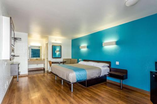 a bedroom with a bed and a blue wall at Motel 6-Bryan, TX - College Station in Bryan