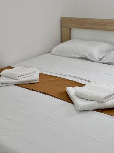 two beds with white sheets and white towels on them at Bulatović in Ðuranovići