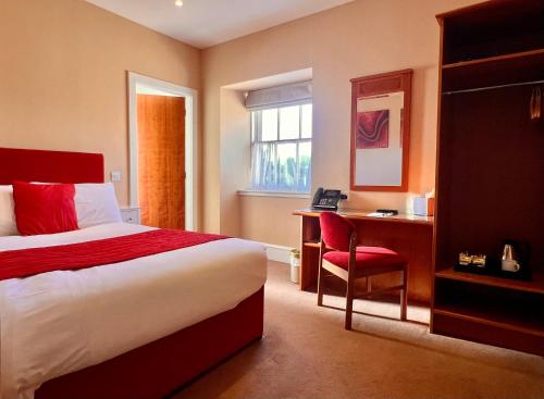 ein Hotelzimmer mit Bett und Schreibtisch in der Unterkunft Laichmoray Hotel in Elgin