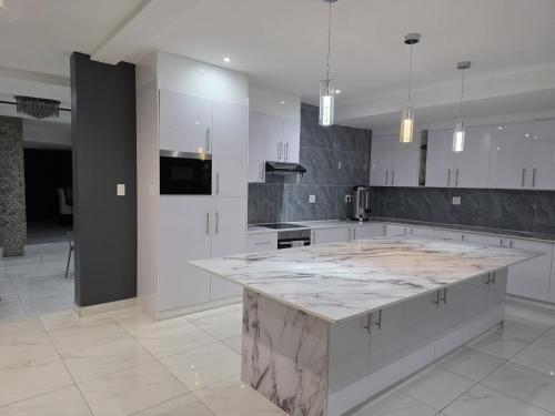 a large white kitchen with a large marble counter top at Blueroof BYO in Bulawayo