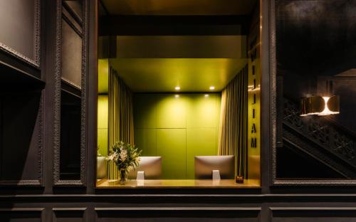 a bathroom with two toilets and a green wall at The William Hotel Midtown, New York in New York