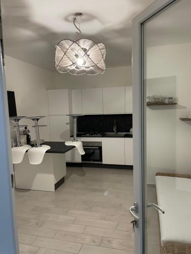 a kitchen with white cabinets and a chandelier at Casa Mare Sabaudia in Sabaudia