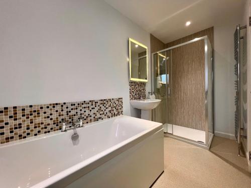 ein weißes Badezimmer mit Badewanne und Waschbecken in der Unterkunft Laichmoray Hotel in Elgin