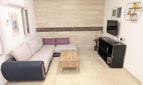 a living room with a couch and a coffee table at Old City Charm in Beer Sheva