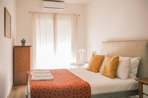 a bedroom with a bed with orange and white pillows at Quinta das Conchas Apartment by Trip2Portugal in Lisbon