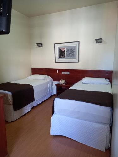 a hotel room with two beds in a room at Cheverny Apart Hotel in Belo Horizonte