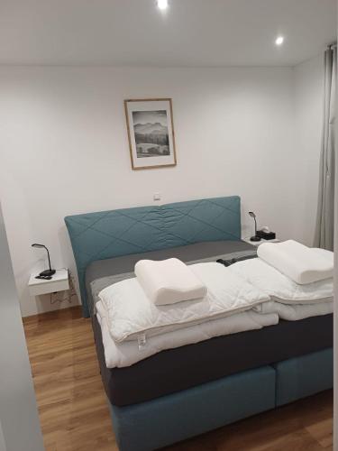 a bedroom with a blue bed with two pillows on it at Ferienapartment "Zur Linde" in Breitenstein