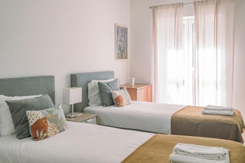 a hotel room with two beds and a window at Quinta das Conchas Apartment by Trip2Portugal in Lisbon